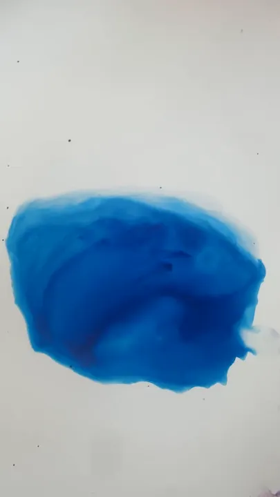 Film: yellow ink dropped from a pipette into a pool of blue
