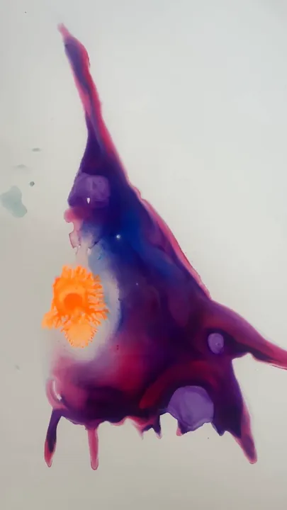 Film: drops of orange and yellow ink spreading in purple