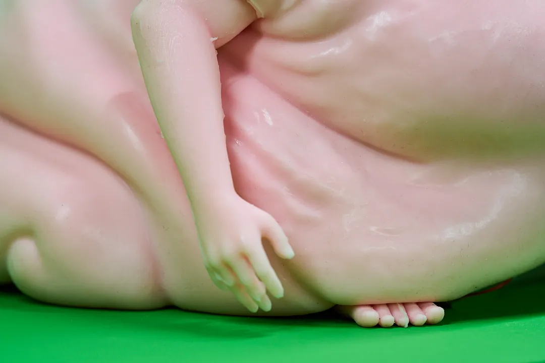 Close-up of a pink lump with a doll-like hand and feet